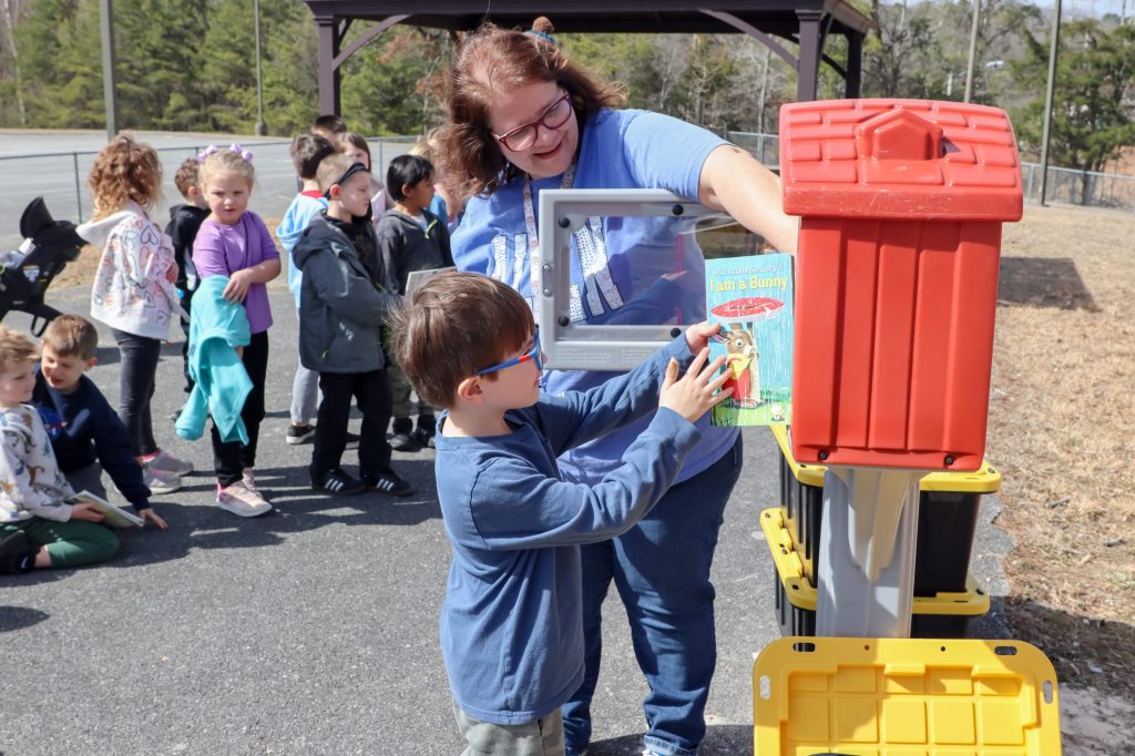 A teacher helps a student get a book